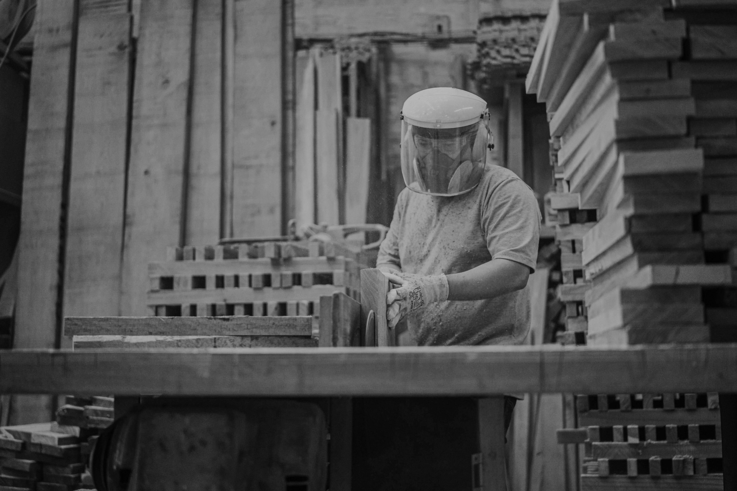 man cutting wood in lumber yard